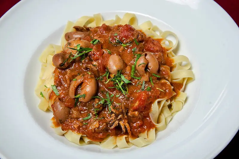 Tagliatelle aux supions, à la provençale : Supions poêlés avec des oignons, déglacés au vin blanc puis mijotés dans une sauce tomate légèrement pimentée.