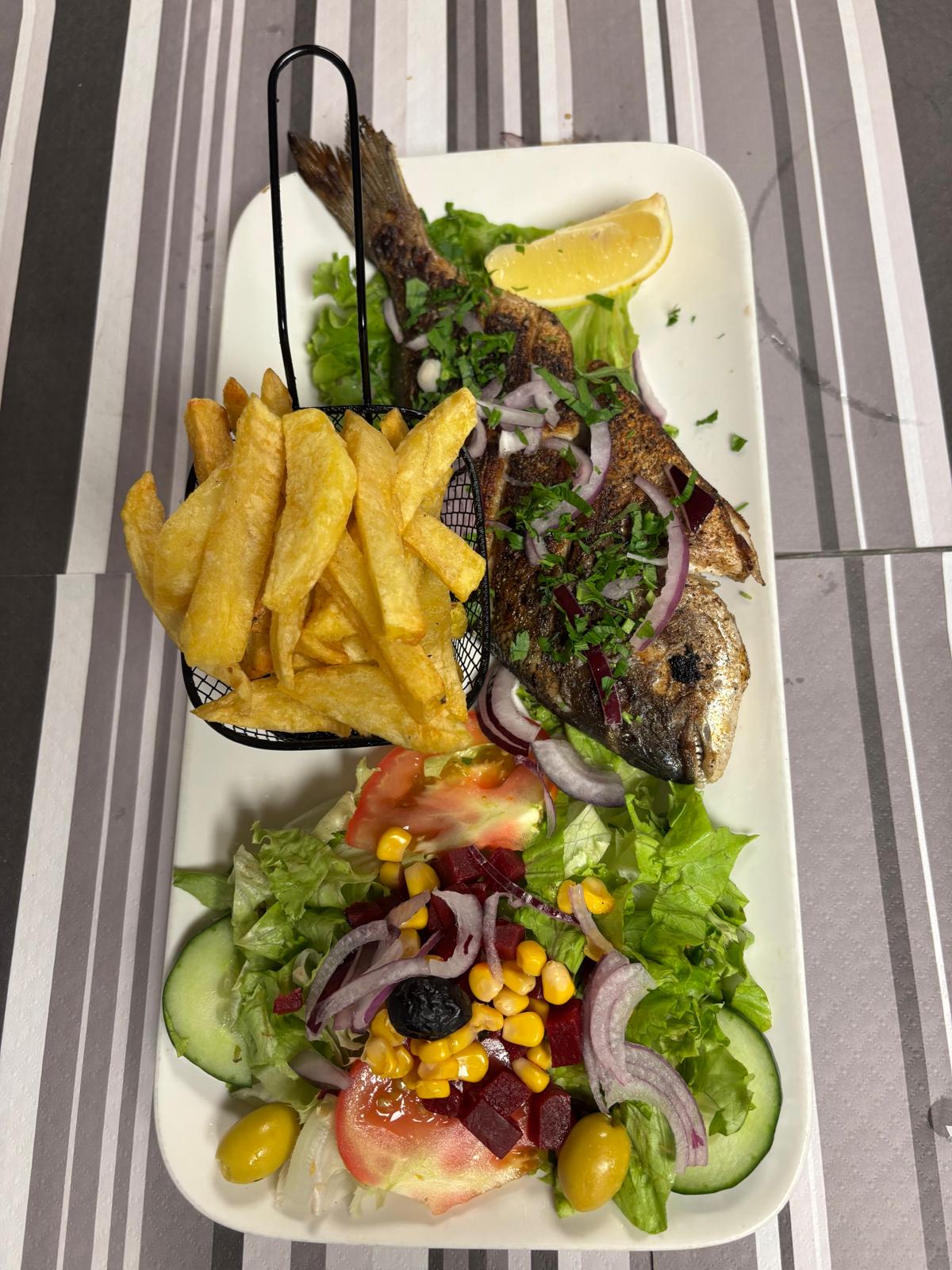 Daurade ou loup (selon arrivage) : Daurade ou loup selon l’arrivage, grillé entier à la plancha, servi avec frites maison, salade fraîche et mezzés