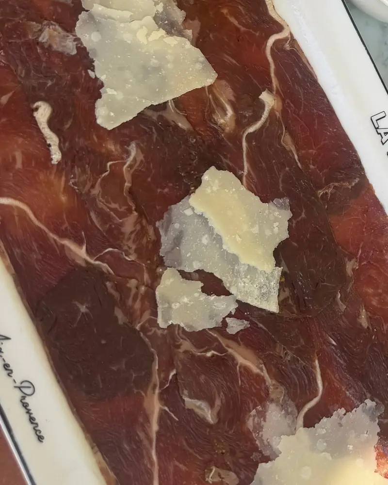 Carpaccio de bœuf fumé : Copeaux de Parmigiano Reggiano, frites maison et salade